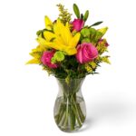 Arranjo de lírios amarelos e rosas pink com monsenhor pompom verde visto por outro ângulo