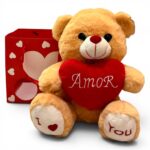 Urso de pelúcia segurando coração vermelho com a palavra Amor